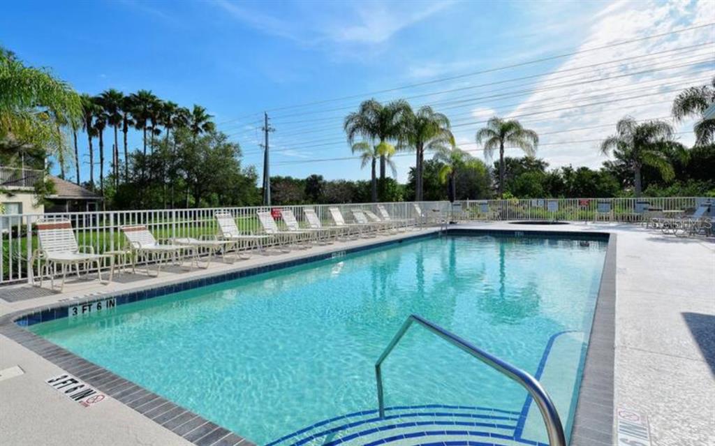 7189 Strand Circle, Unit 1 Bradenton, FL 34203 - Photo 14 of 19 a view of a swimming pool with a garden and outdoor seating