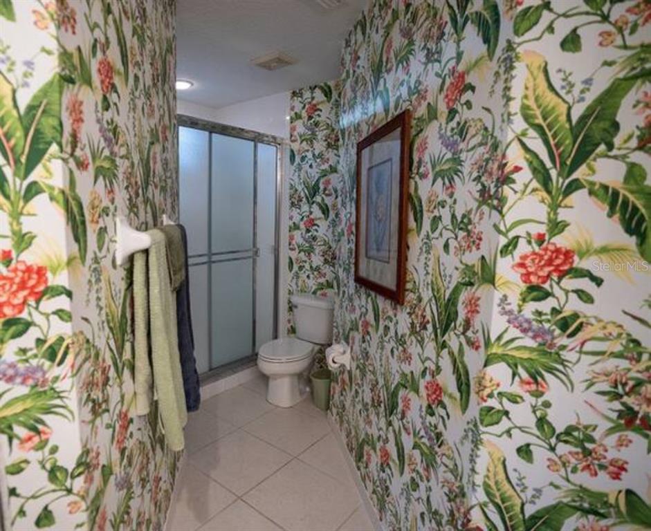 7189 Strand Circle, Unit 1 Bradenton, FL 34203 - Photo 7 of 19 a bathroom with a toilet and shower curtain