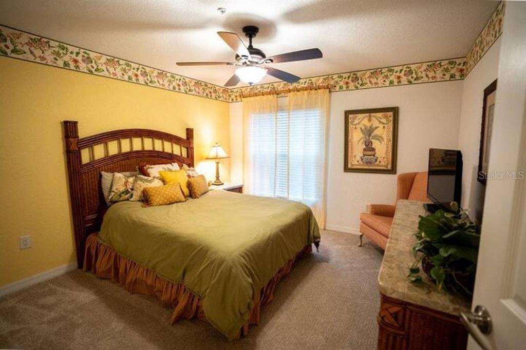 7189 Strand Circle, Unit 1 Bradenton, FL 34203 - Photo 9 of 19 a bedroom with a bed and a chandelier