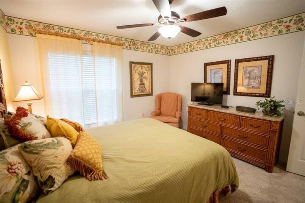 7189 Strand Circle, Unit 1 Bradenton, FL 34203 - Photo 10 of 19 a bedroom with a bed and a chandelier