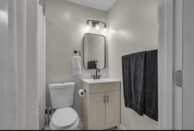 a bathroom with a toilet a sink and mirror