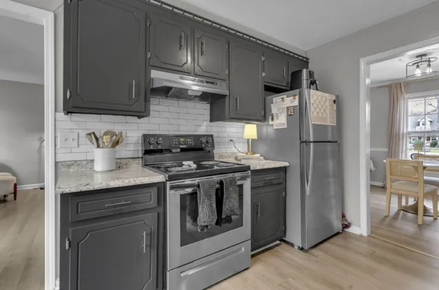 a kitchen with stainless steel appliances granite countertop a refrigerator stove and sink