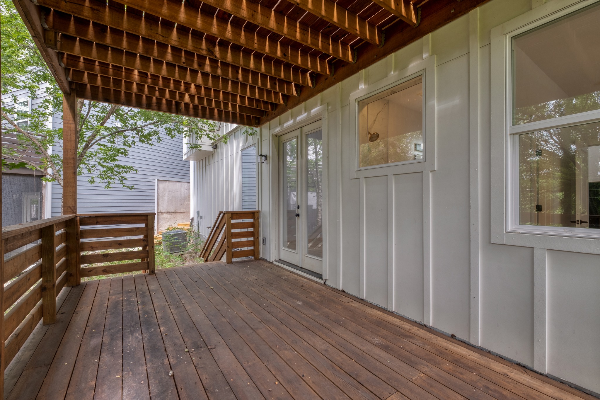 5211 Rob-Scott Street Austin, TX 78721 - Photo 21 of 24 A spacious wooden deck provides ample outdoor living beneath a finished ceiling and board-and-batten siding.