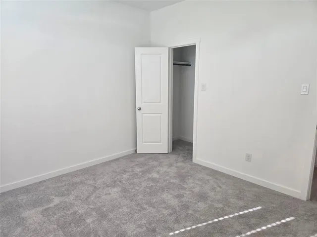 an empty room with closet and a window