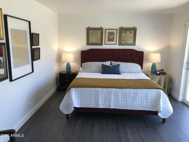 a bedroom with a bed and wooden floor