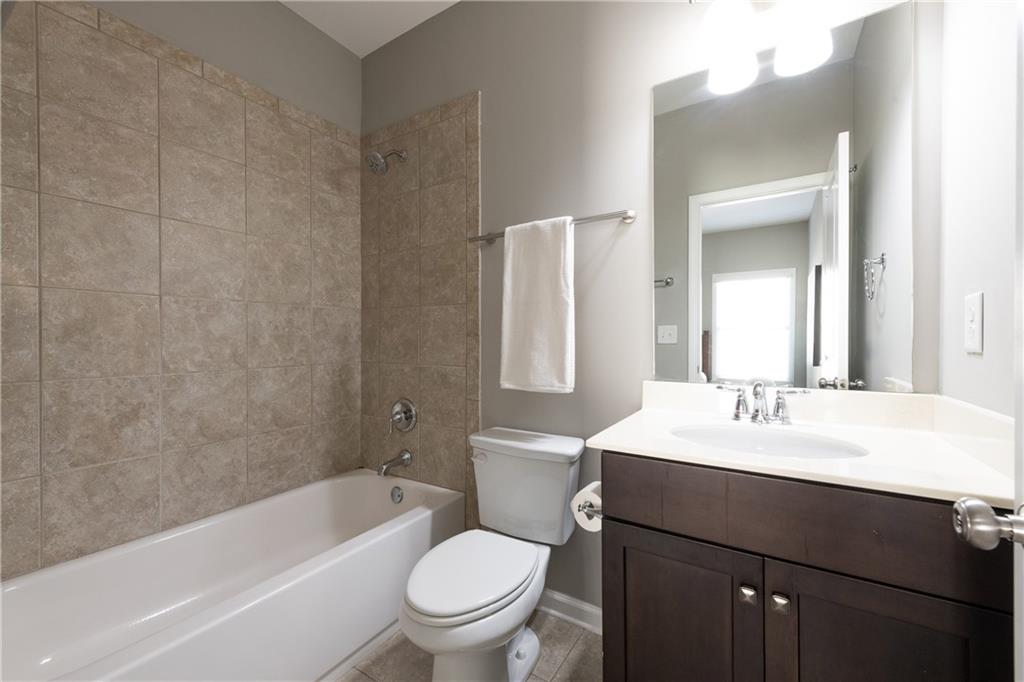 2199 Collins Ridge Drive Northwest Atlanta, GA 30318 - Photo 28 of 50 a bathroom with a sink a toilet a mirror a bathtub and shower