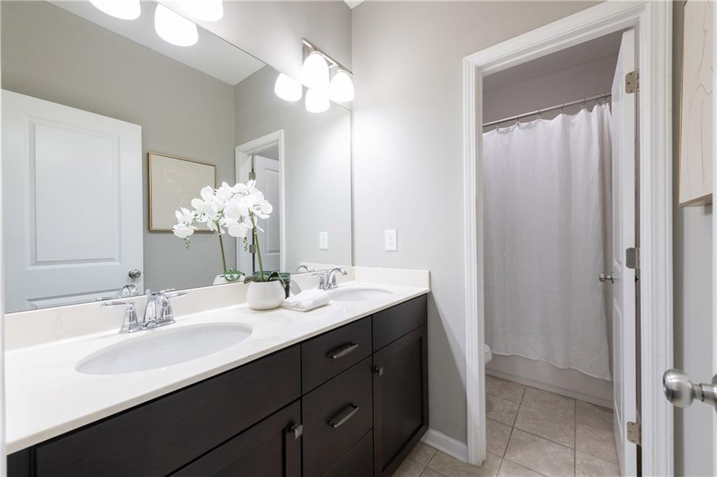 2199 Collins Ridge Drive Northwest Atlanta, GA 30318 - Photo 30 of 50 a bathroom with a double vanity sink a mirror and a shower