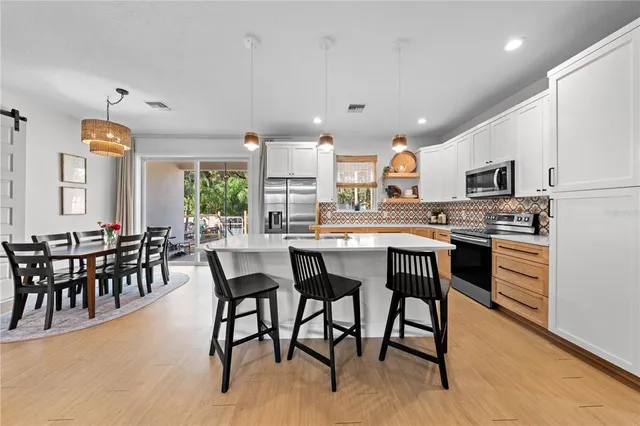 a kitchen with kitchen island a dining table and chairs