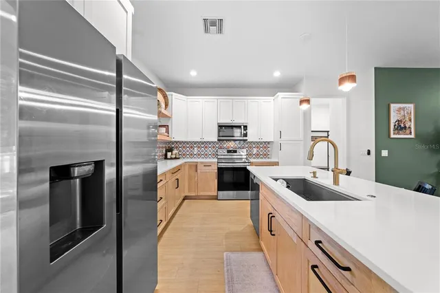 a large kitchen with stainless steel appliances and a sink