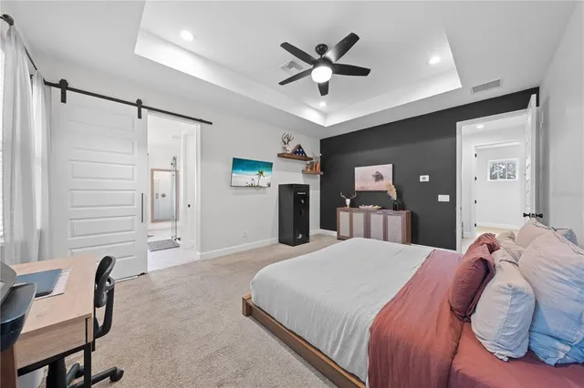 a bedroom with a large bed and a chandelier