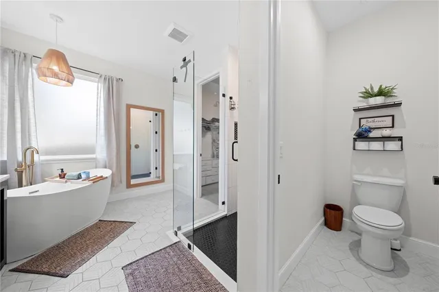 a bathroom with a toilet a sink and a large mirror