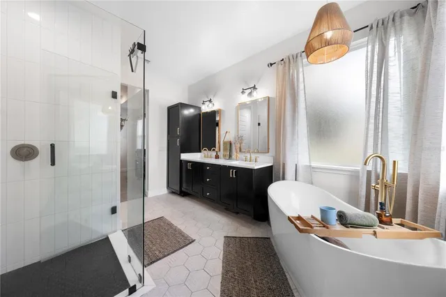 a bathroom with a tub a sink and mirrors