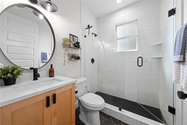 a bathroom with a sink a toilet and shower