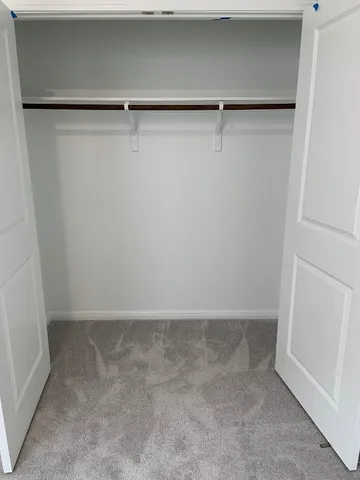 a view of walk in closet with empty racks