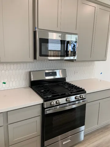 a kitchen with stainless steel appliances granite countertop a stove and a microwave