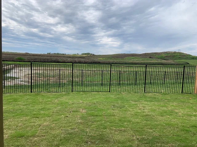 a view of green field with wooden fence