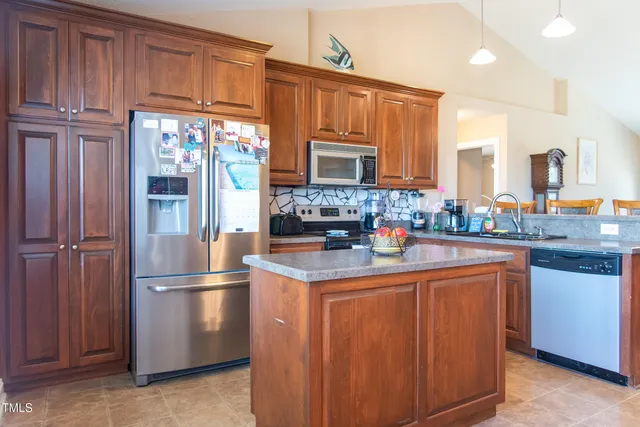 a kitchen with stainless steel appliances granite countertop a refrigerator and a stove
