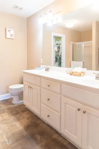 a bathroom with a granite countertop toilet sink and mirror