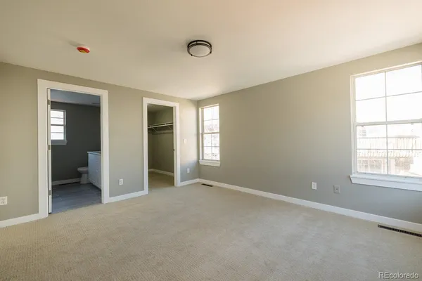 a view of an empty room with a window and bathroom