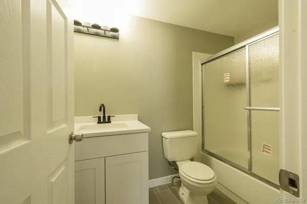 a view of an empty room with wooden floor and stairs