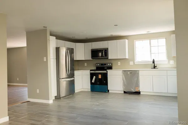 a kitchen with white cabinets and stainless steel appliances