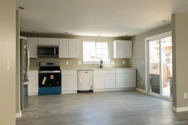 a kitchen with a refrigerator and a stove top oven
