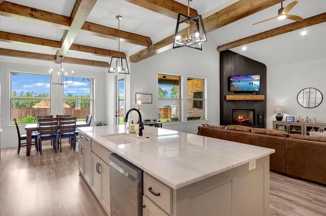 a kitchen with sink a counter top space and living room area