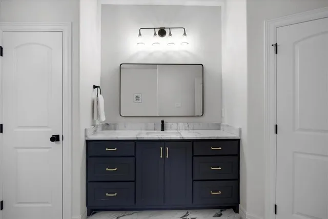 a bathroom with a granite countertop sink and a mirror