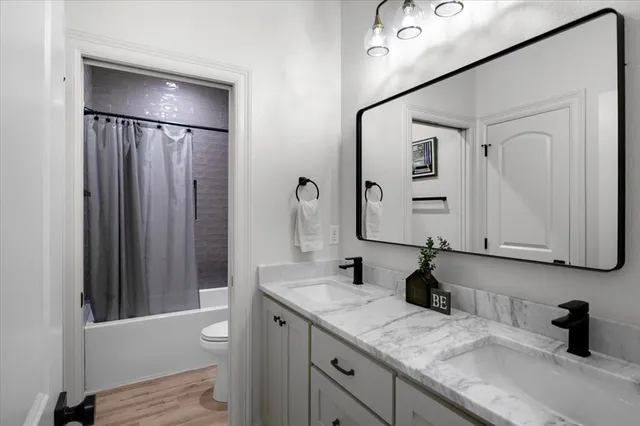 a bathroom with a double vanity sink mirror and shower