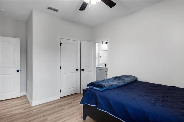 a bedroom with a bed and a chandelier fan