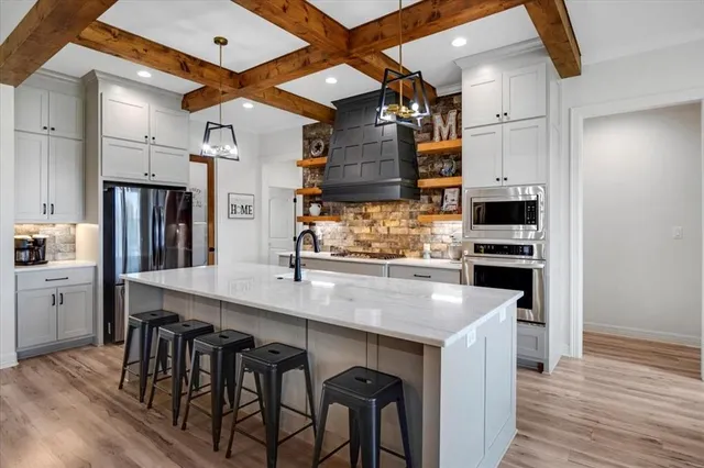 a kitchen with stainless steel appliances granite countertop a kitchen island a stove and a refrigerator