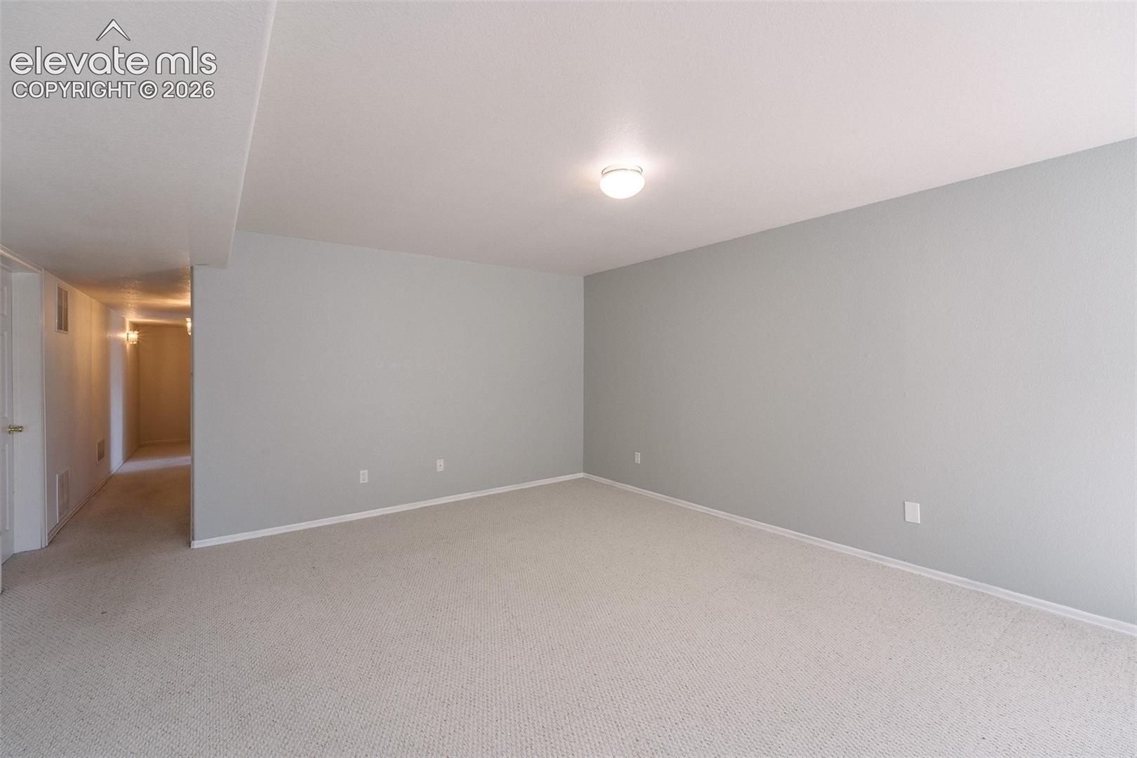 7869 Fort Smith Road Peyton, CO 80831 - Photo 33 of 50 Basement Family Room with hallway to the Bedrooms and Basement Bathroom.