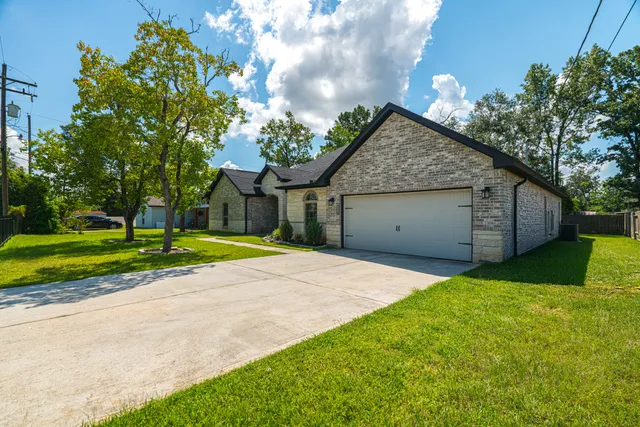 a view of a house with a backyard and a tree