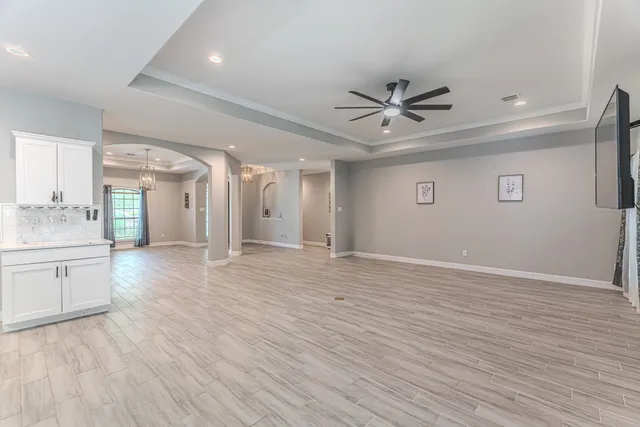 a kitchen with stainless steel appliances a dining table chairs stove refrigerator and cabinets