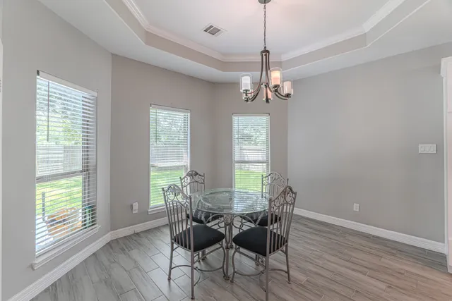 a kitchen with stainless steel appliances kitchen island granite countertop a dining table chairs and granite counter tops