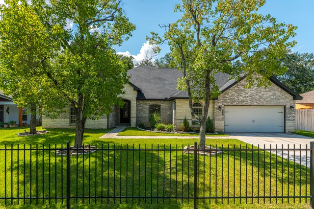 a view of a house with backyard and trees