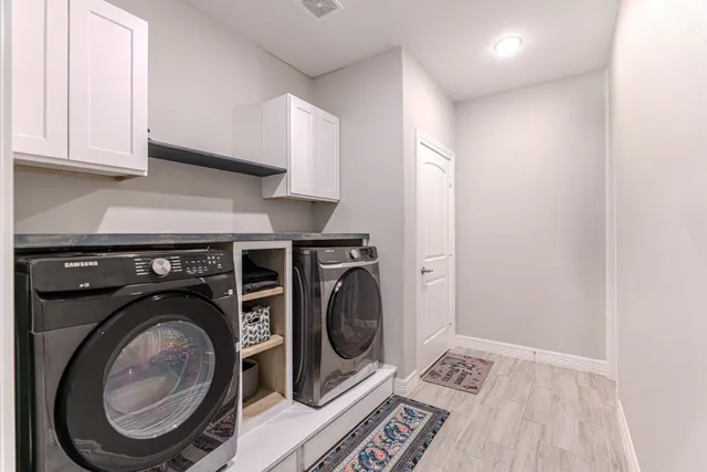 a spacious bedroom with a bed a couch and a chandelier