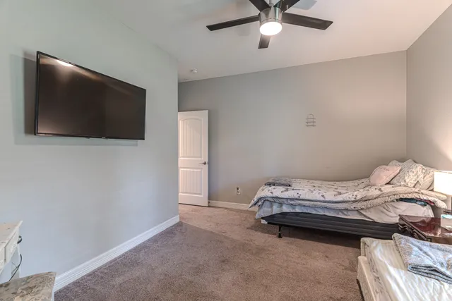 a bedroom with a bed chandelier and a window