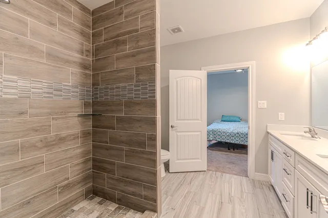 a view of a patio with table and chairs under an umbrella with a tub and a small yard