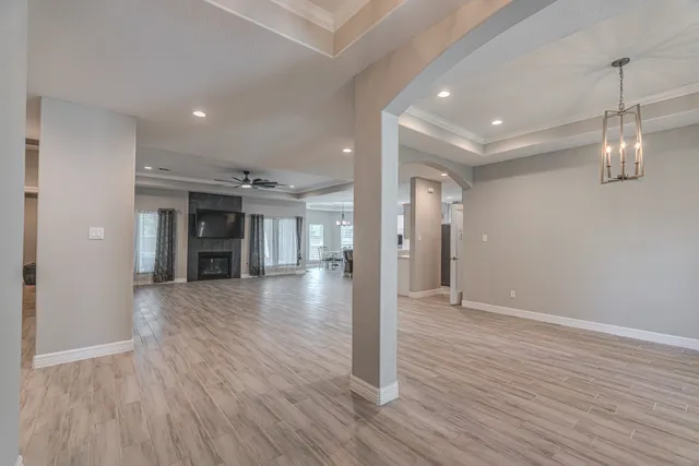 a view of a hallway with wooden floor and a window