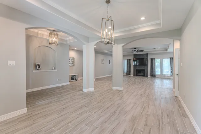 a view of a room with wooden floor staircase and a kitchen