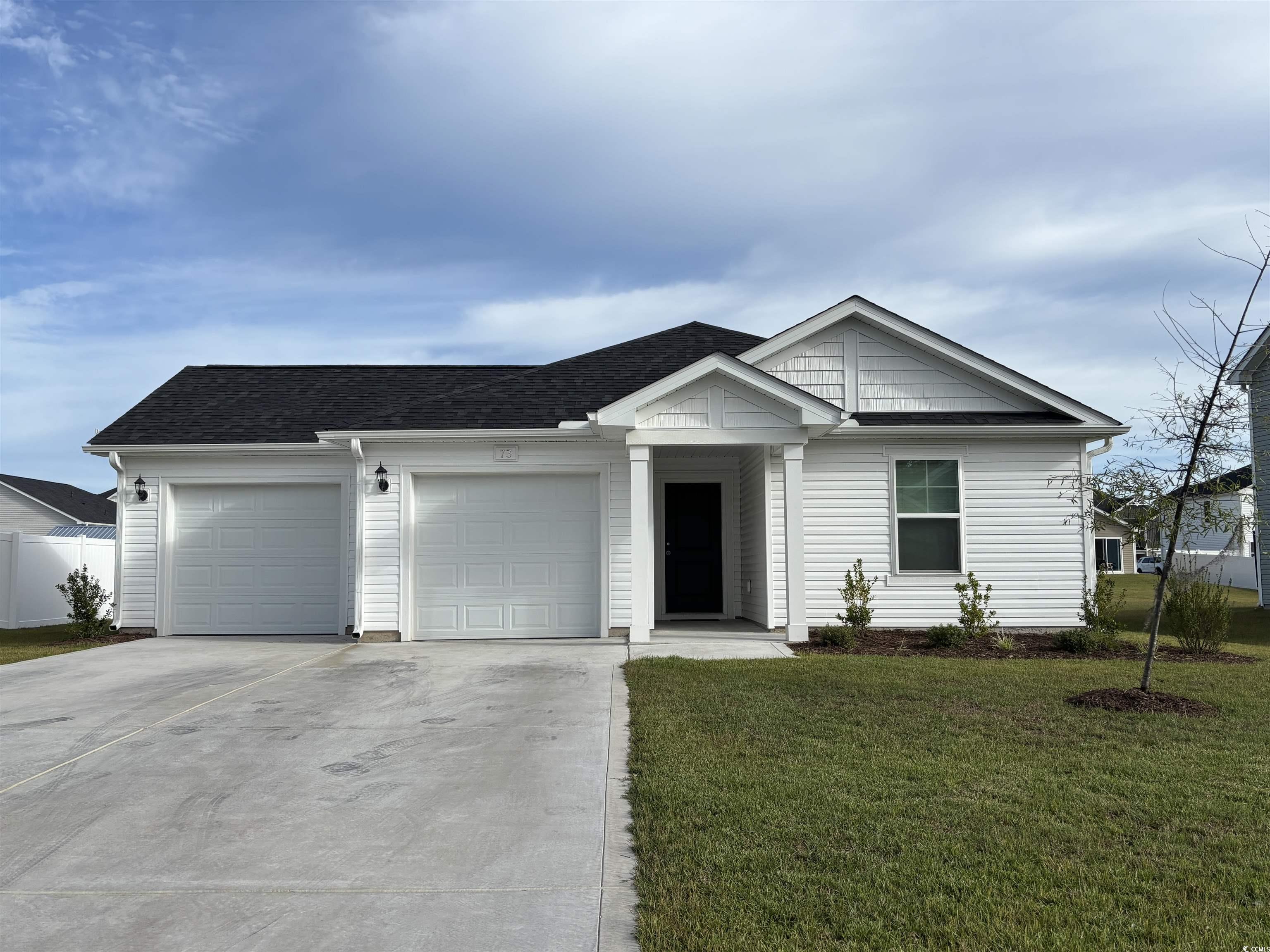 Ranch-style home with driveway, a front lawn, a garage, and roof with shingles