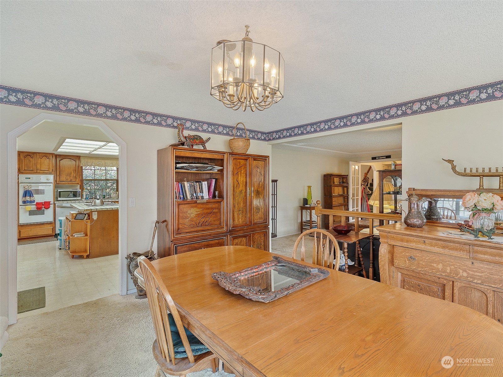 5814 Northwest 169th Street Ridgefield, WA 98642 - Photo 15 of 40 a dining room with wooden floor a chandelier a wooden table and chairs