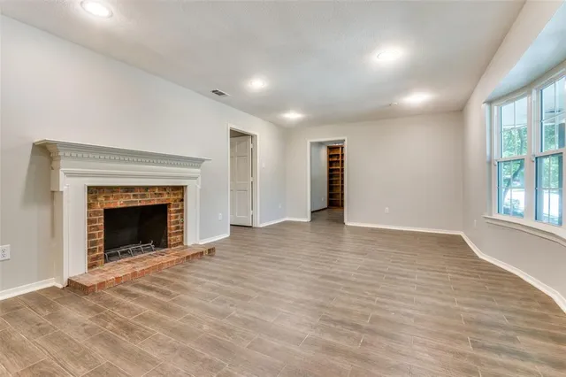 a view of an empty room with window and fire place