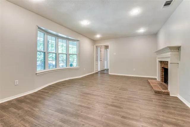 an empty room with wooden floor and a window