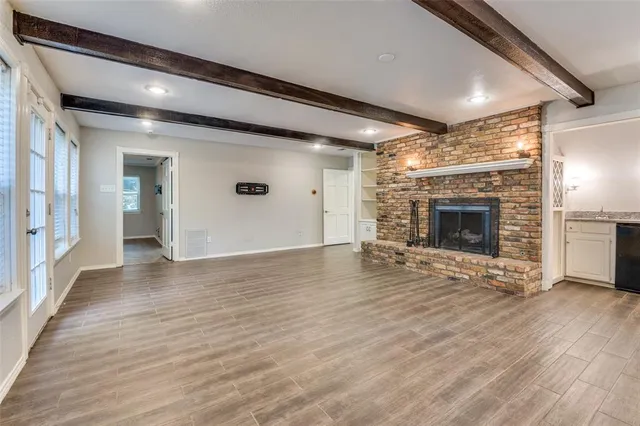 an empty room with wooden floor and fireplace