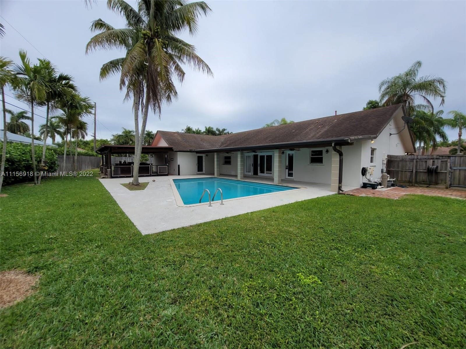 a view of house with a garden and swimming pool