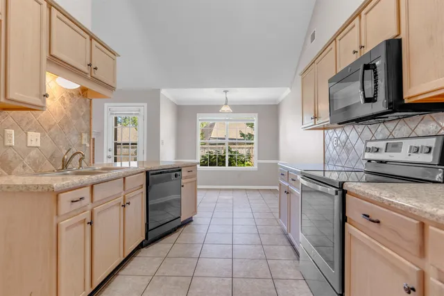 a kitchen with stainless steel appliances granite countertop a sink and a stove