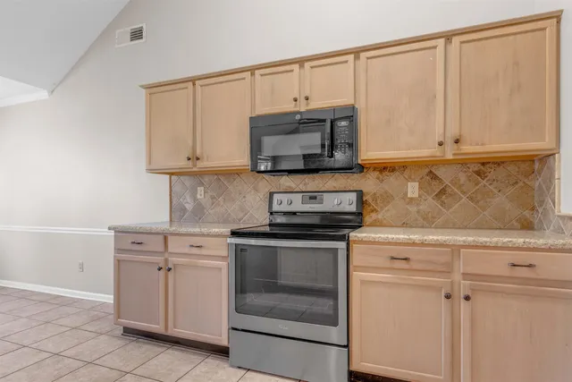 a kitchen with granite countertop white cabinets and stainless steel appliances