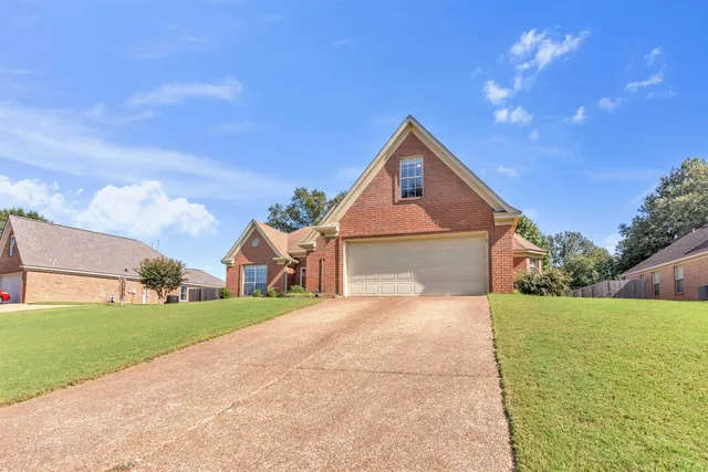 a front view of a house with a yard and garage